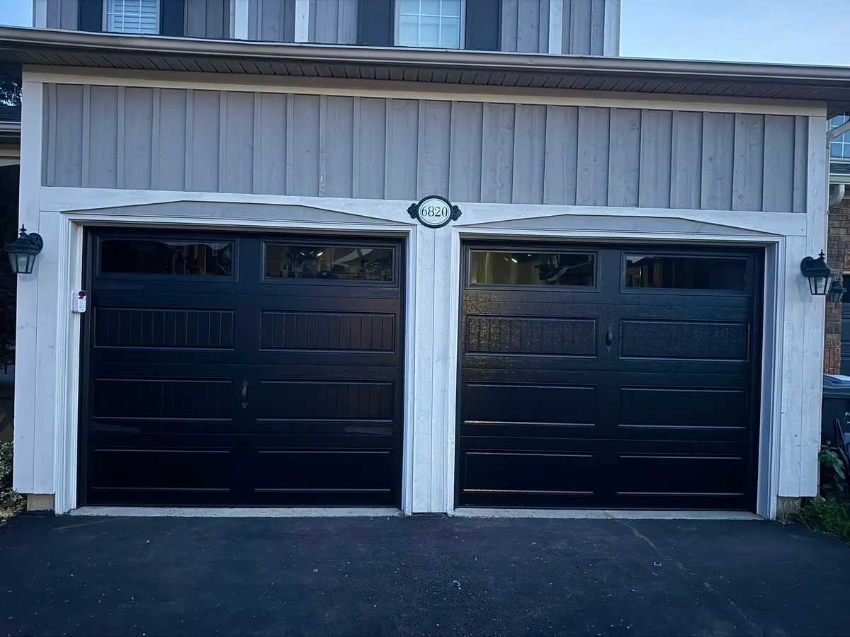 Pair of black carriage-style garage doors with top windows