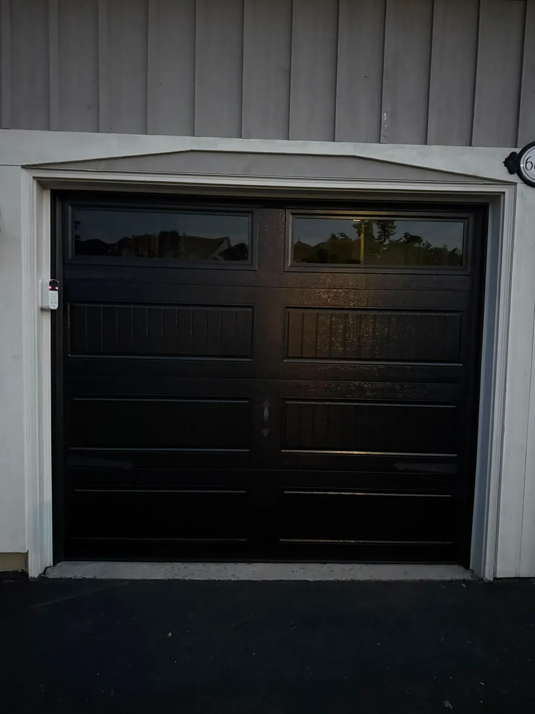 Black carriage-style single garage door with top windows