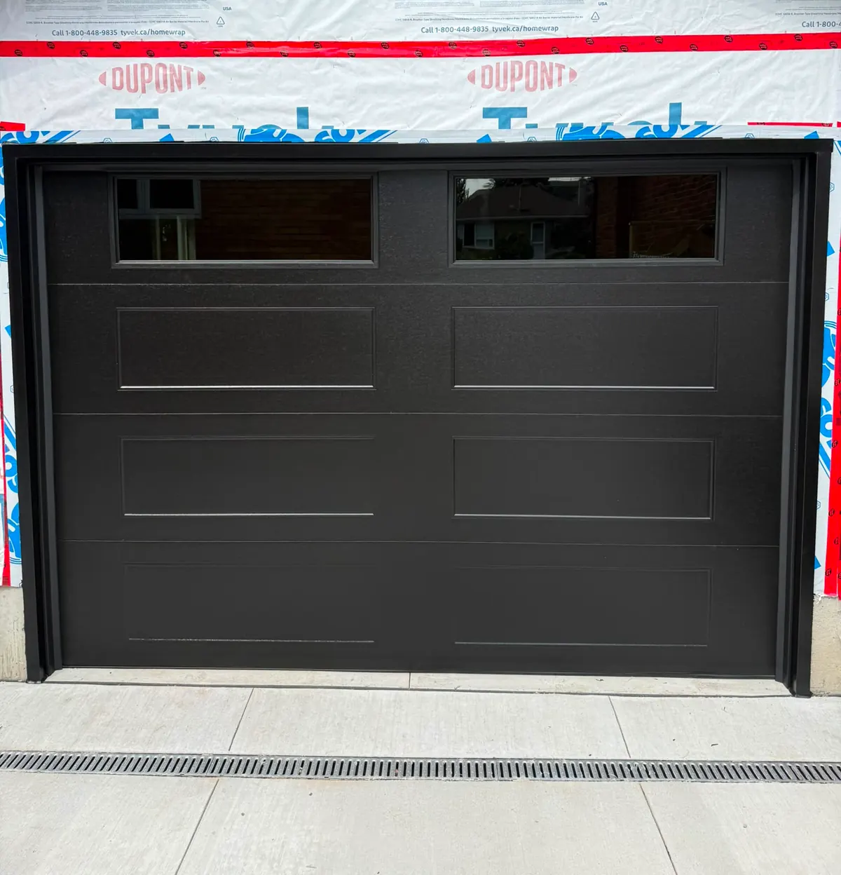 Black long-panel single garage door on a new-build home