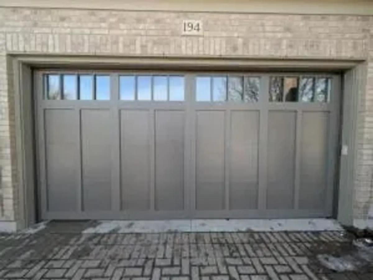 Greige carriage-style double garage door with divided top windows — North York