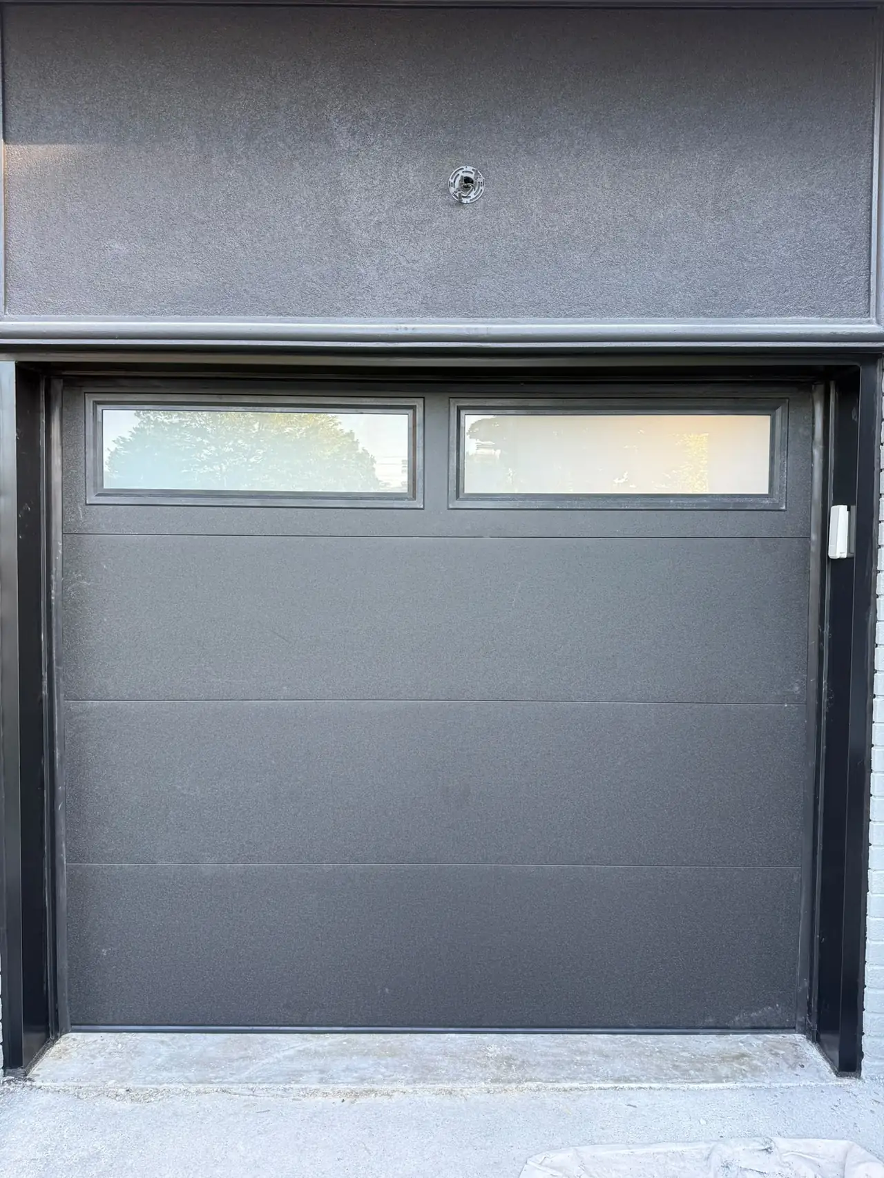 Grey modern flush-panel garage door with top windows