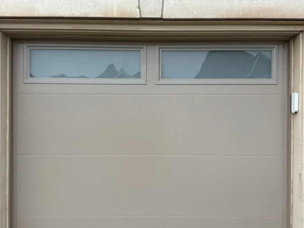 Steel sectional door with decorative windows